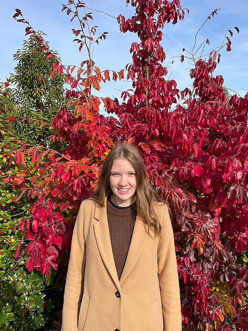 Bild von Laura vor einem bunten Baum