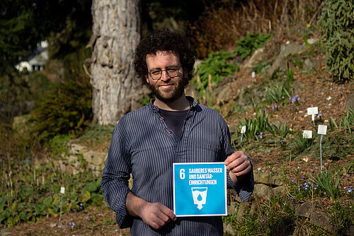 Andreas Kolb hält SDG6 hoch.