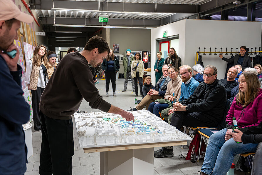 Julian Numberger von NUWELA Büro für Städtebau und Landschaftsarchitektur erläutert den Entwurf am Modell bei der öffentlichen Zwischenpräsentation im März 2024 am Campus Nord