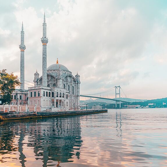 Der Blick vom Wasser auf die Bosporus Brücke und eine Moschee in Istanbul.