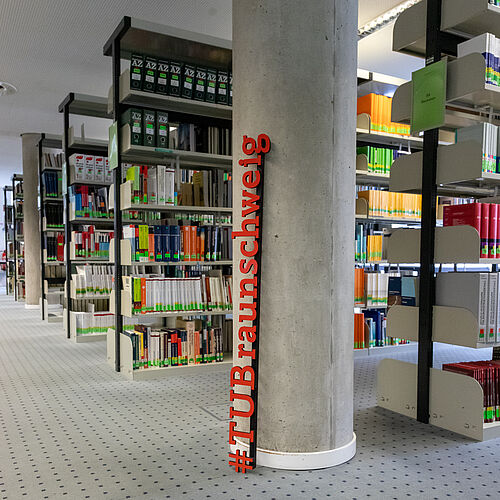 You can see an interior view of the university library with various bookshelfs