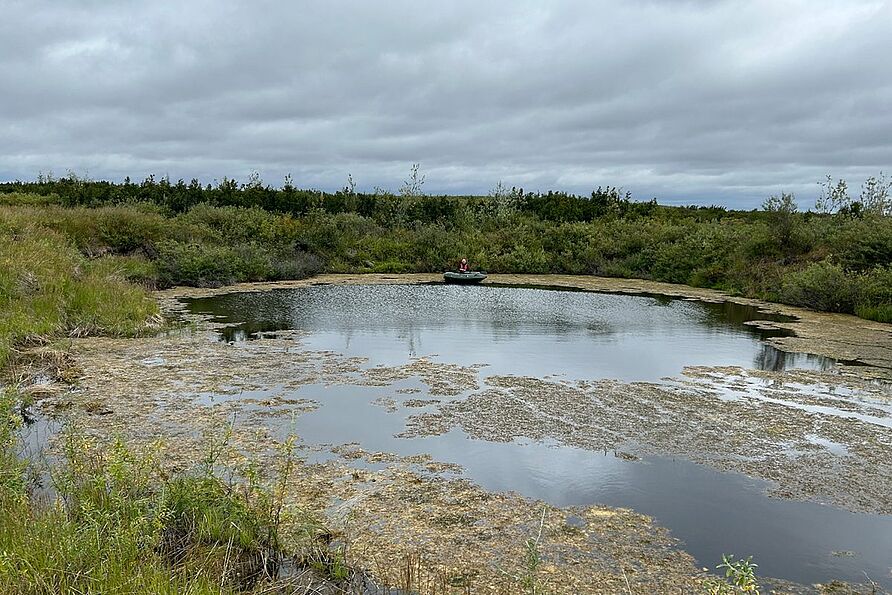 Emma Cameron bei der Entnahme von Sediment- und Wasserproben aus einem Kleingewässer, der sich auf dem Grubendeckel gebildet hat.