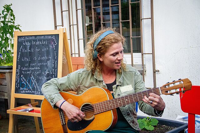 Interkulturelles Buffet im Welcome House, Person spielt Gitarre