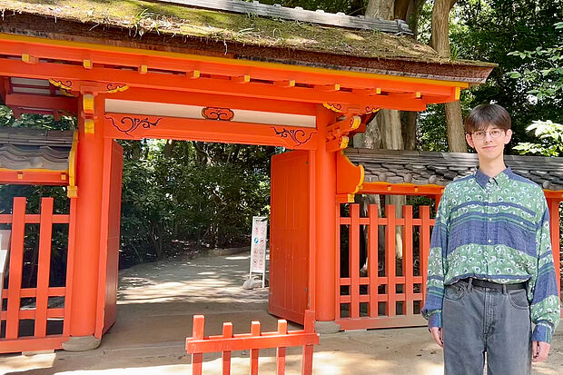 Biology student Benjamin Harder stands in front of a torii gate at a shrine in Fukuoka. 