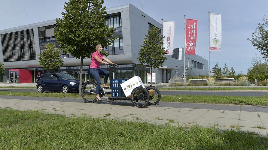 Frau auf einem Lastenfahrrad vor dem NFF-Forschungsbau in Braunschweig