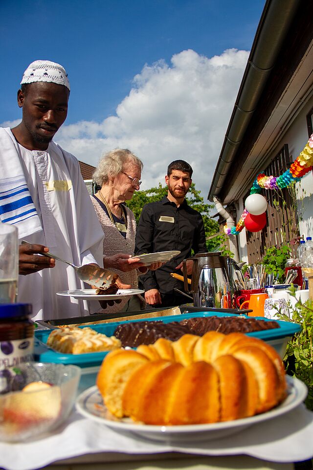 Interkulturelles Buffet im Welcome House: Personen stehen am Buffet