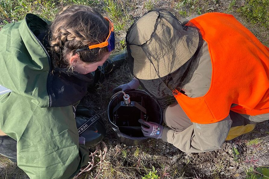 Professorin Antje Schwalb und Emma Cameron bei der Untersuchung einer Sedimentprobe aus einem Teich am Rande einer Bohrschlammgrube.