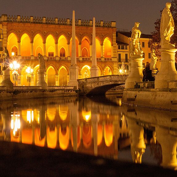 Blick von einem Fluss auf eine Brücke am Abend